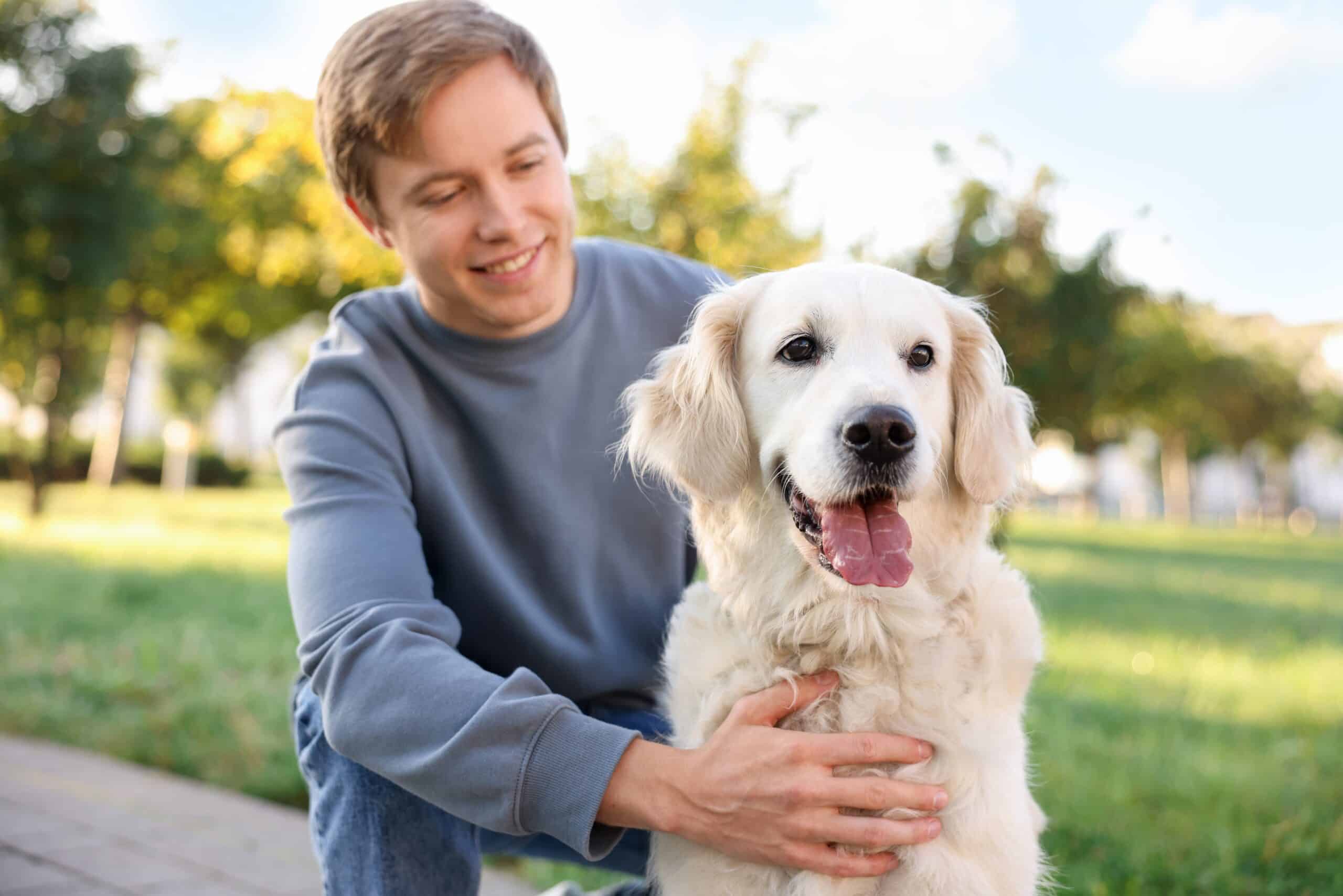 Man,With,His,Adorable,Golden,Retriever,Dog,In,Park